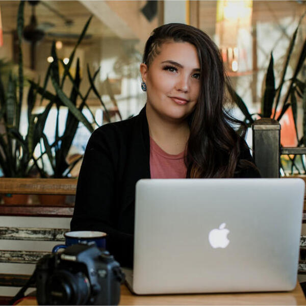 Student working on laptop in coffee shop.